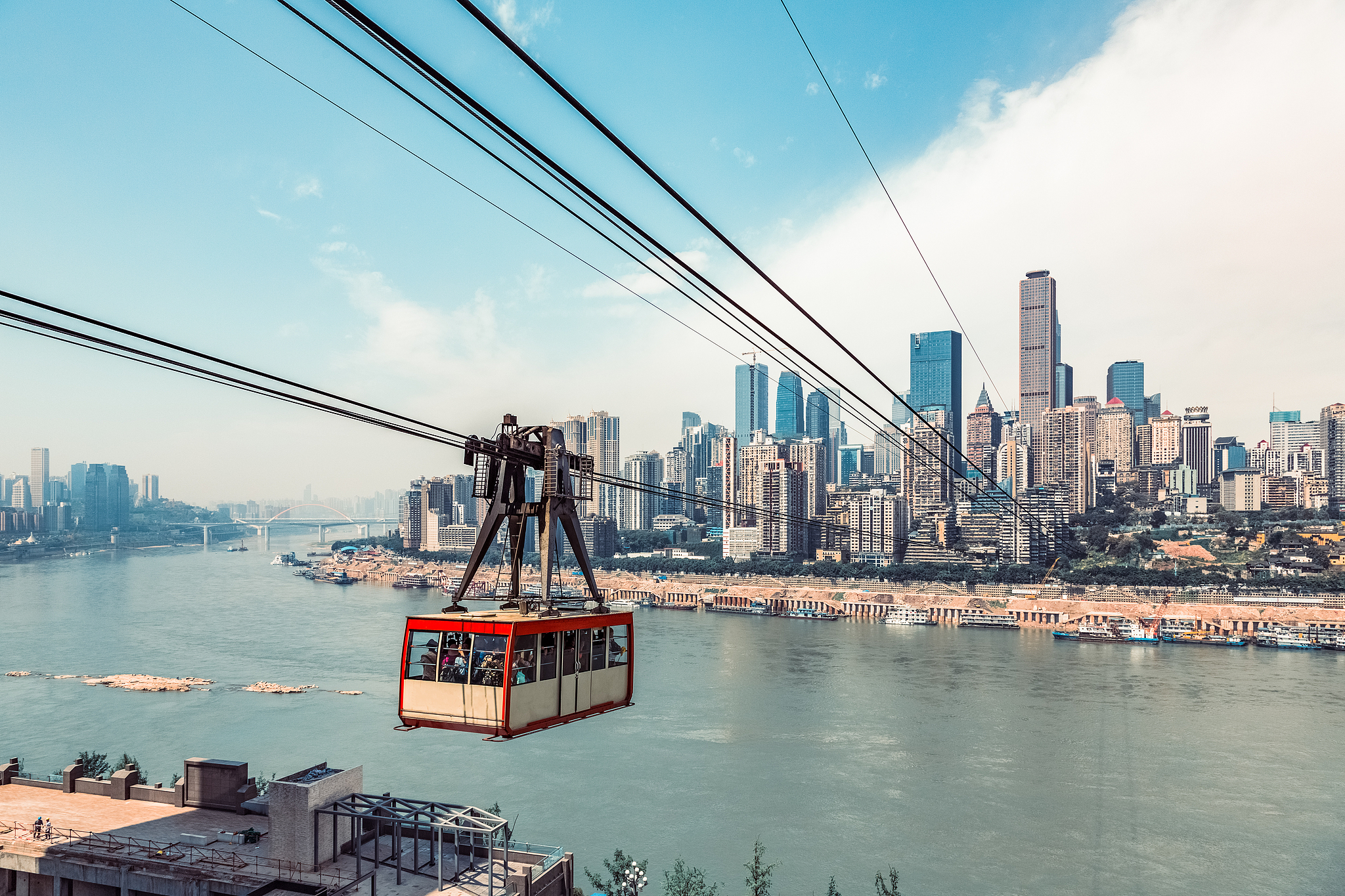 Commuters take a cable car across the Yangtze river in Chongqing,China