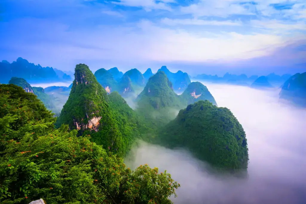 Malerische Landschaftsaufnahme der markanten Karstberge in Guilin, China, umhüllt von dichtem Morgennebel.