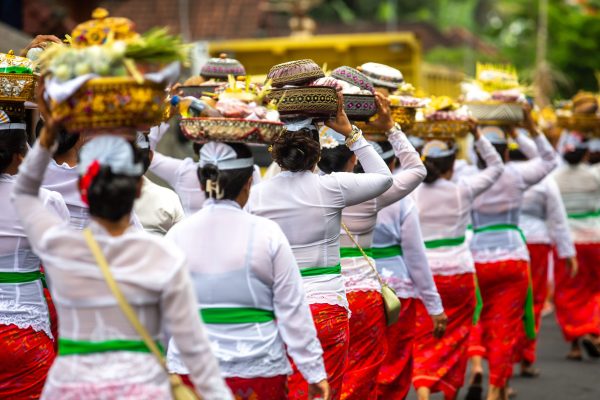 Photograph of a group of unrecognizable women during a traditional ceremony in front of a temple