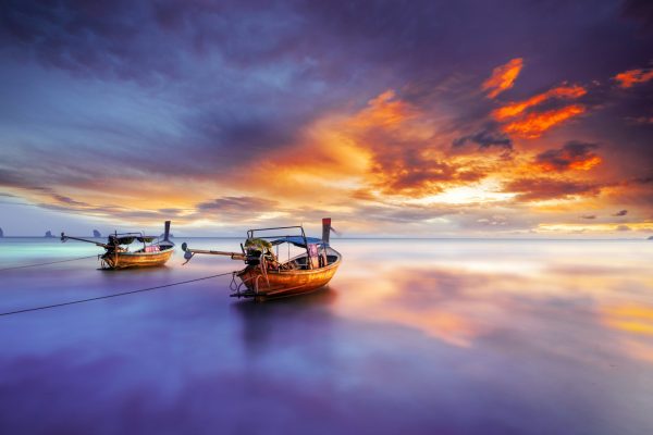 Traditional long-tail boat on the beach in Krabi Thailand at sunset